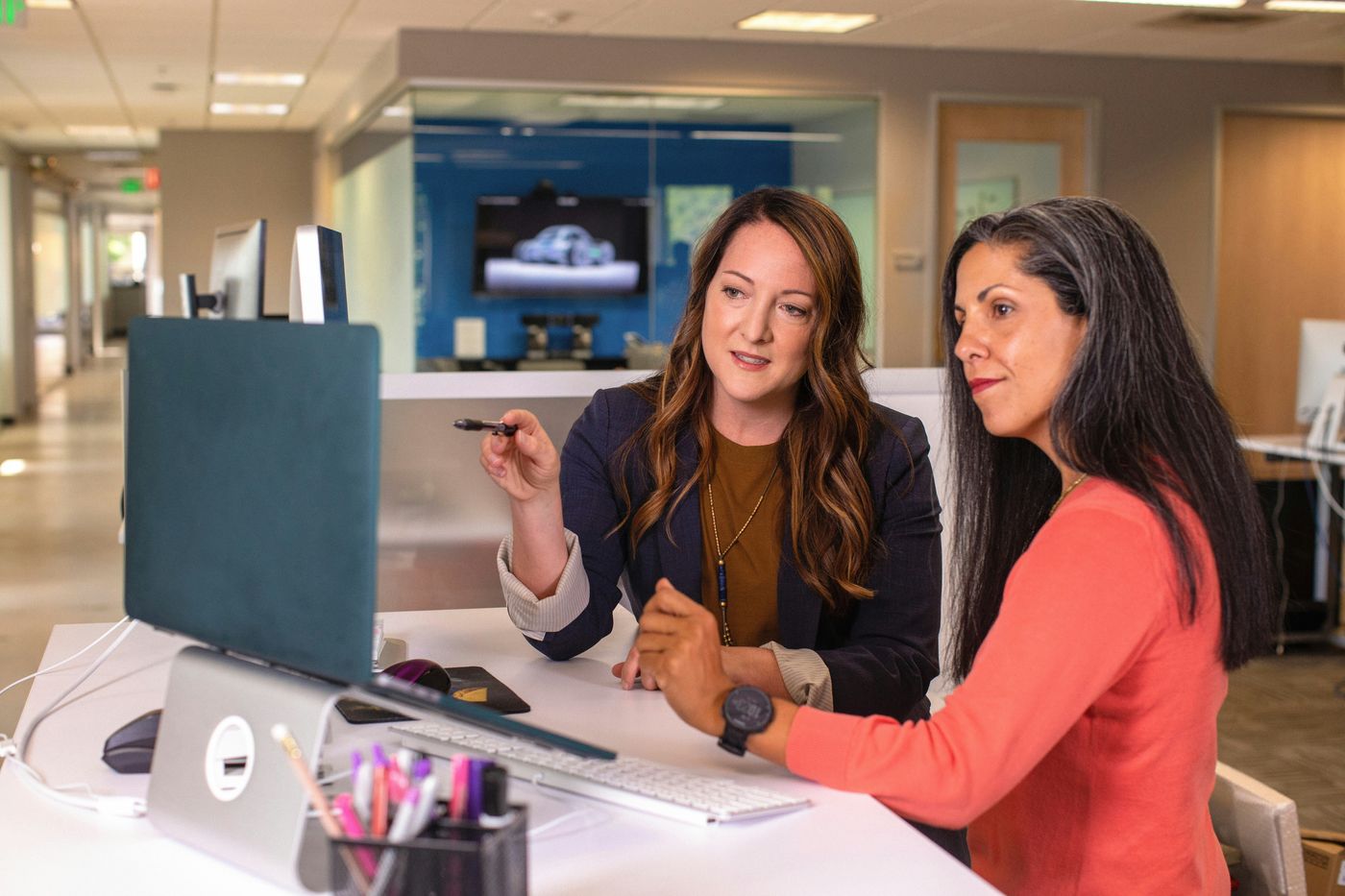 A coach and client reviewing finances together at a computer